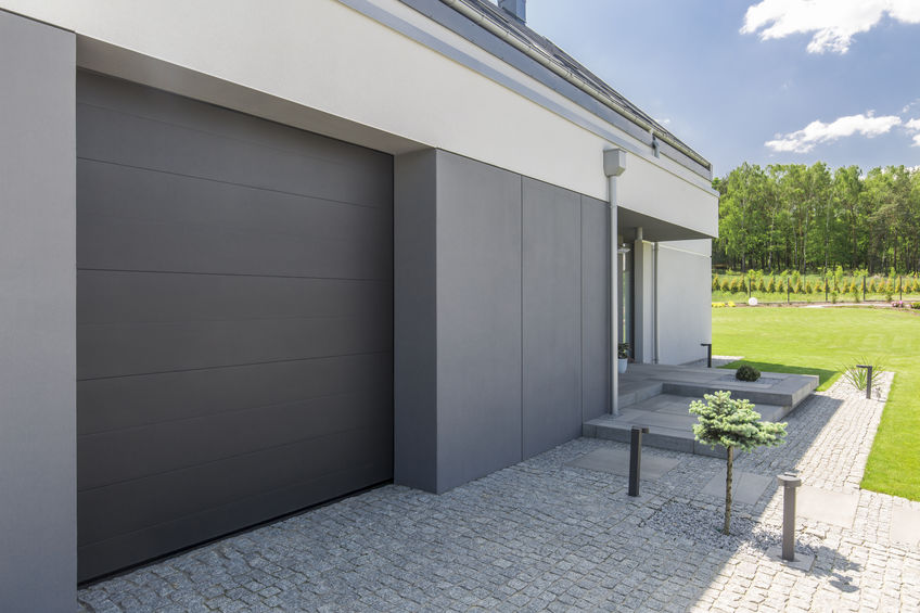 Šedé sekční garážová vrata k modernímu domu